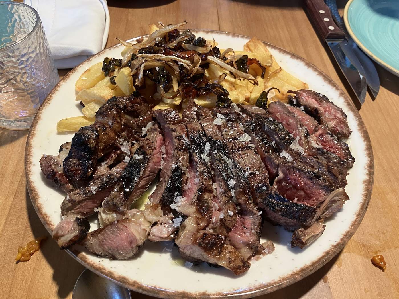 Entrecot de ternera a la parrilla con patatas fritas caseras y cebolla caramelizada